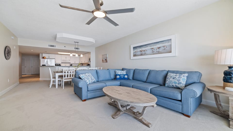 A comfortable living room with ample seating, flowing into a dining area, ideal for everyday living and gatherings.