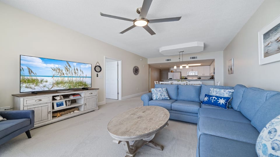 This well-appointed living space offers a comfortable sectional sofa, elegant coffee table, and a dining area with seating for eight, creating a welcoming atmosphere.