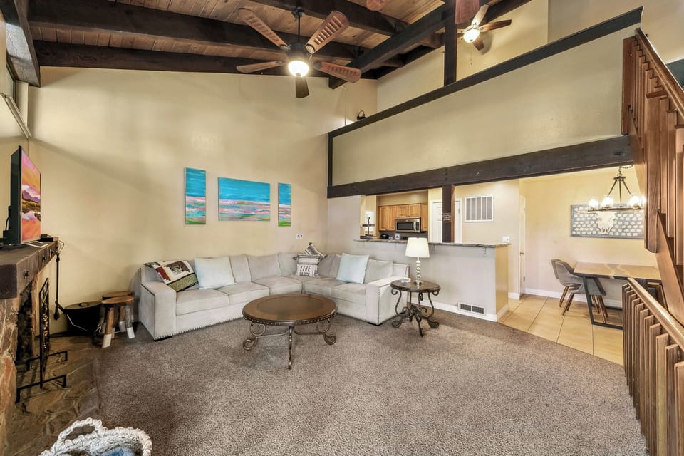 Relax in your spacious living room featuring rustic exposed beams, cozy sectional seating, and an open-concept layout perfect for memorable gatherings.