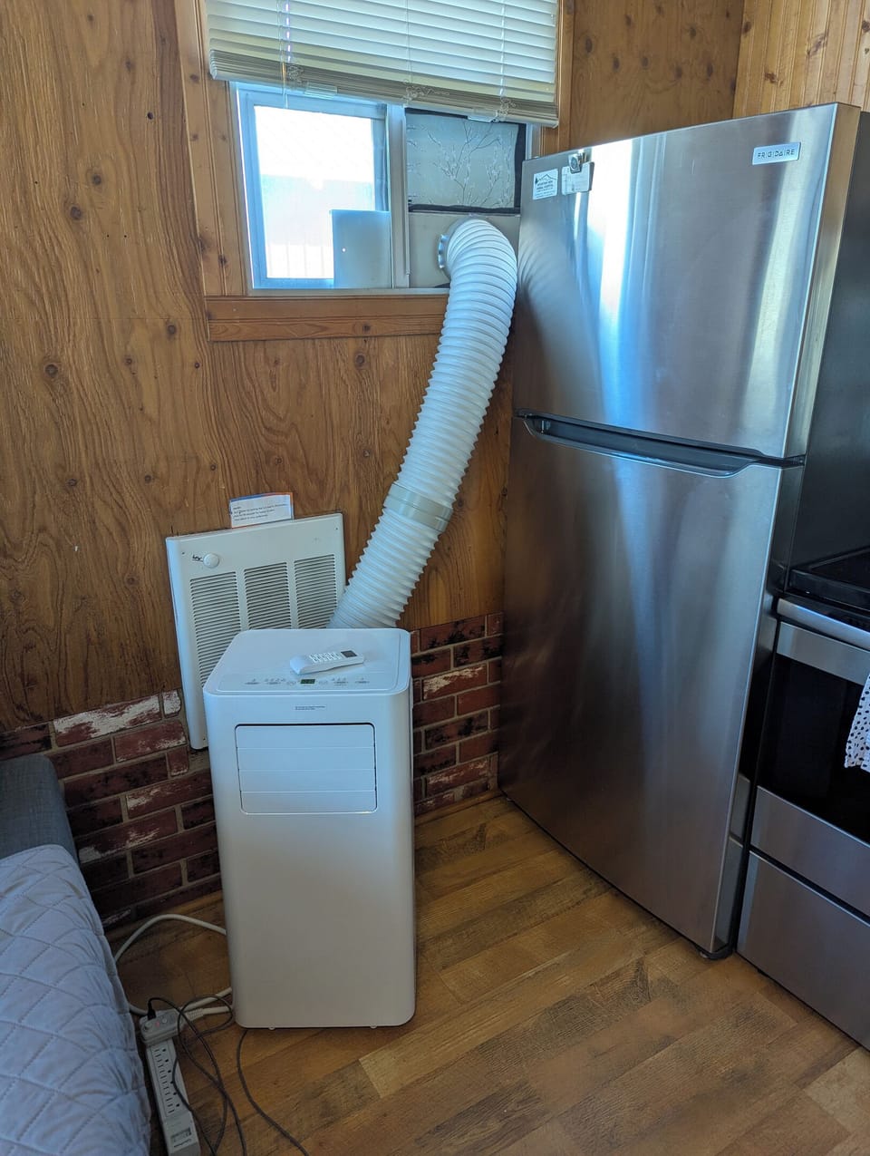 Portable AC. The only window for install. Please be careful in opening the refrigerator doors! This does not cool the upstairs. There are windows on each end upstairs that open plus fans and a small water cooler on the nightstand.