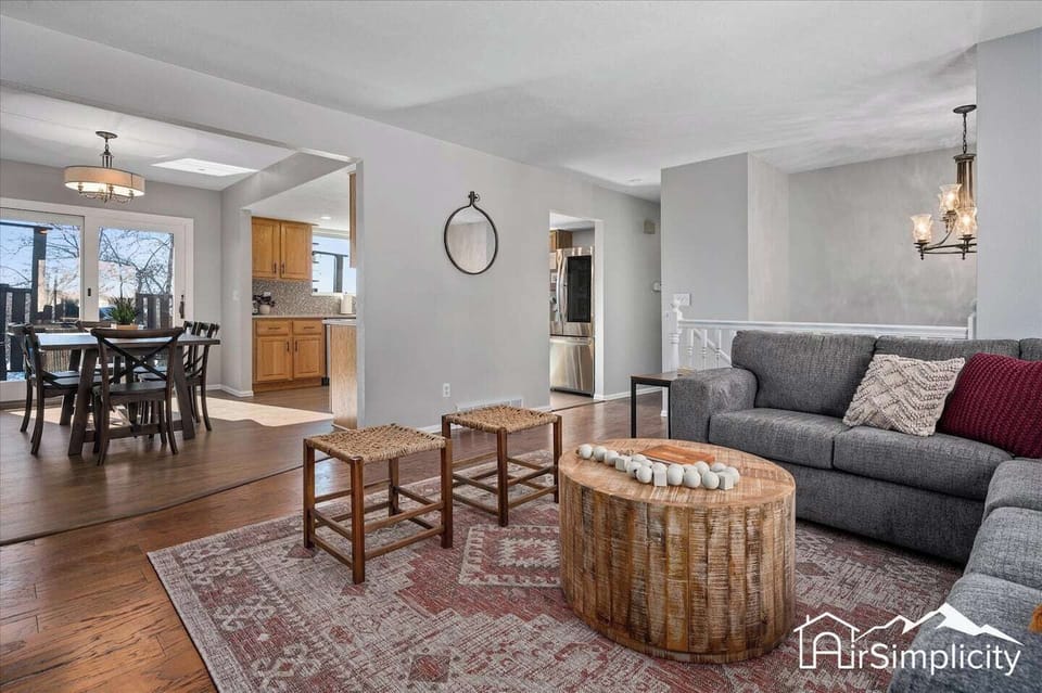 - Open layout seamlessly connects the living room to kitchen and hallway for easy flow
- Neutral walls and wood flooring create a warm, cohesive base throughout the home
- Ideal for hosting, relaxing, or watching a movie on the cozy gray sectional