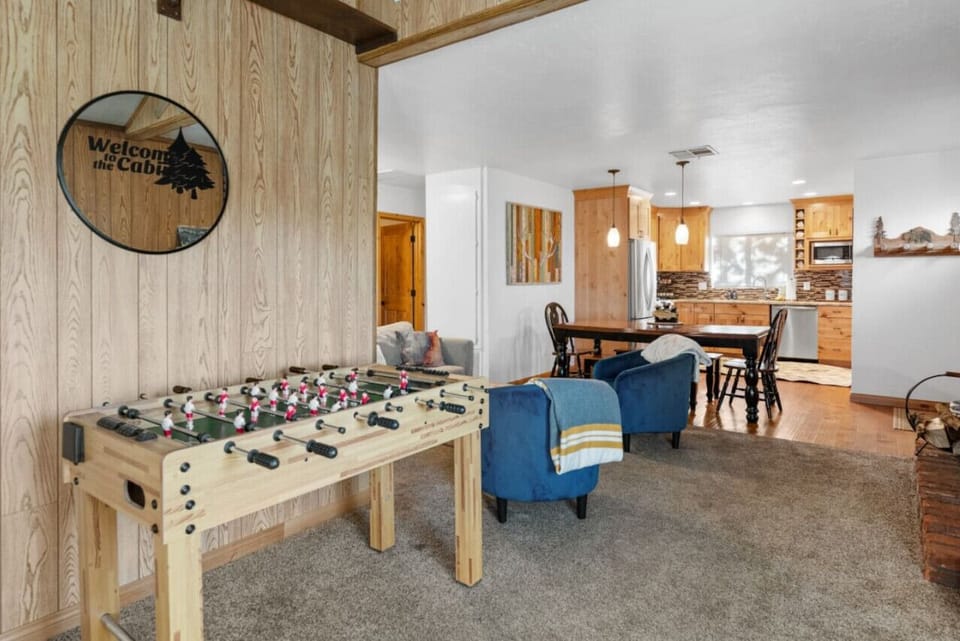 Inviting living area w/ foosball table, cozy seating, & open flow into the dining space and kitchen.