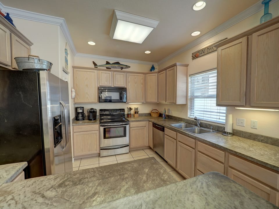 Kitchen organized with all dishes, glasses, silverware, Keurig pods, dish pods. 