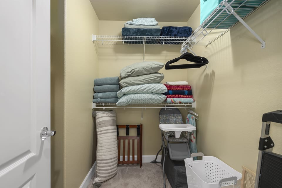 Master walk-in closet with extra sheets, pillows and supplies