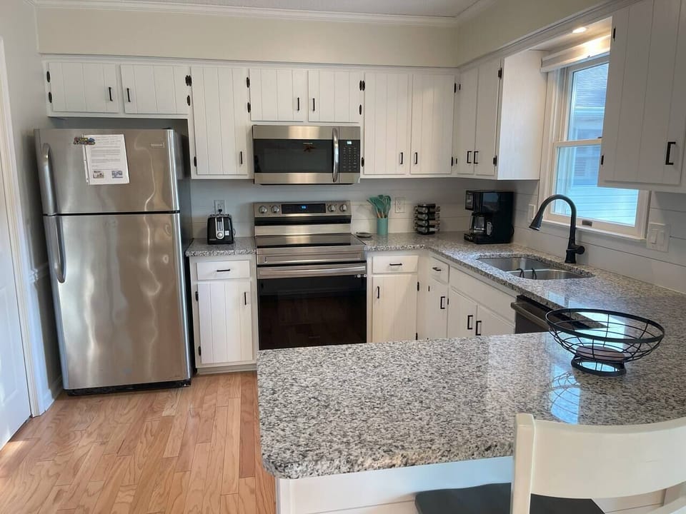 Coastal cuisine never looked so good! Our kitchen features stunning granite countertops and a shiplap backsplash that will transport you straight to the beach.  #coastalkitchen  #granitegoals #shiplaplove #beachvibes #dreamkitchen"