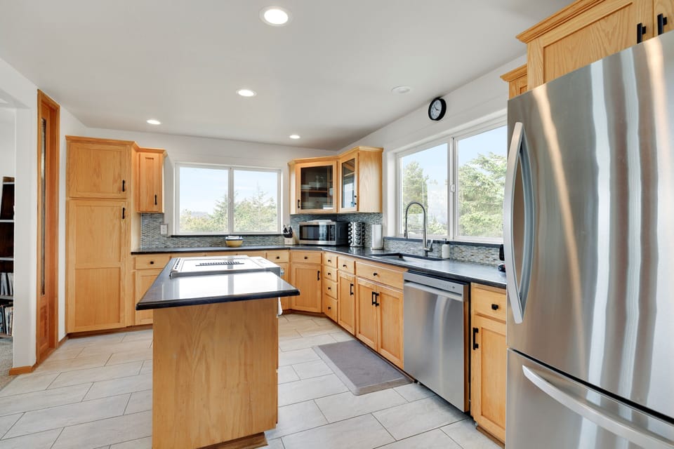 Your fully equipped kitchen features modern stainless steel appliances, granite countertops, and a convenient breakfast bar for morning coffee.