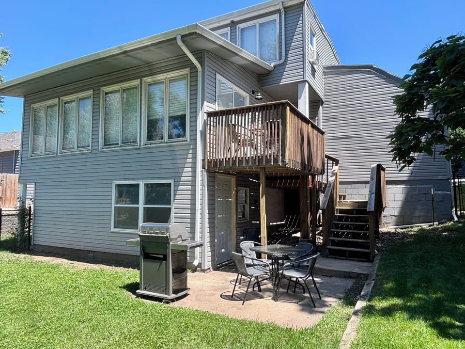 Exterior of the back side of the home- fenced in w/ outdoor seating & grill