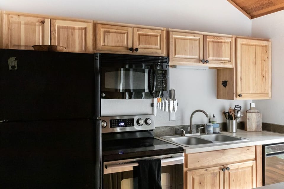 Fully equipped kitchen with refrigerator, microwave, oven/range and dishwasher.