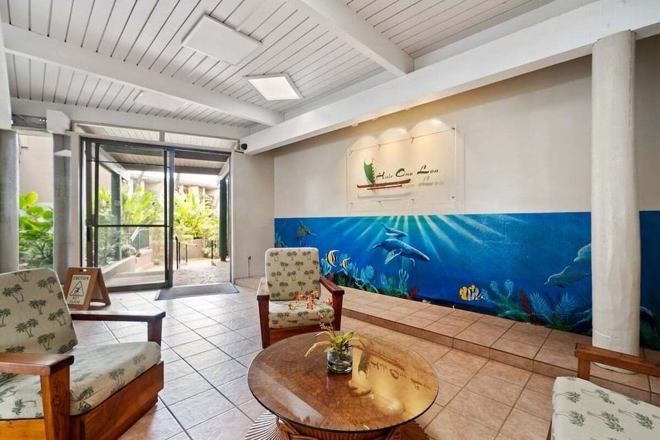 A bright and airy lobby featuring comfortable seating and tropical-themed decor