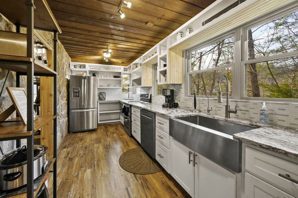Fully equipped kitchen with stainless appliances and quartz counters.