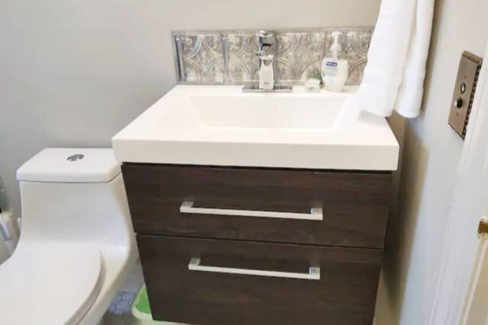 A floating sink with soft close drawers maximizes the floor space of this little bathroom.