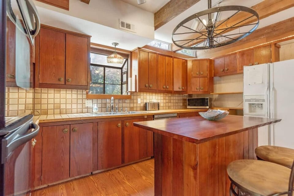 Hand made redwood cabinets and cabinet pulls shaped like carnation flowers are just one thing that make this kitchen one of a kind.