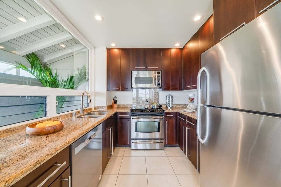 Spacious modern kitchen with stainless steel appliances, granite countertops, and ample cabinetry, perfect for preparing meals during your Maui stay.