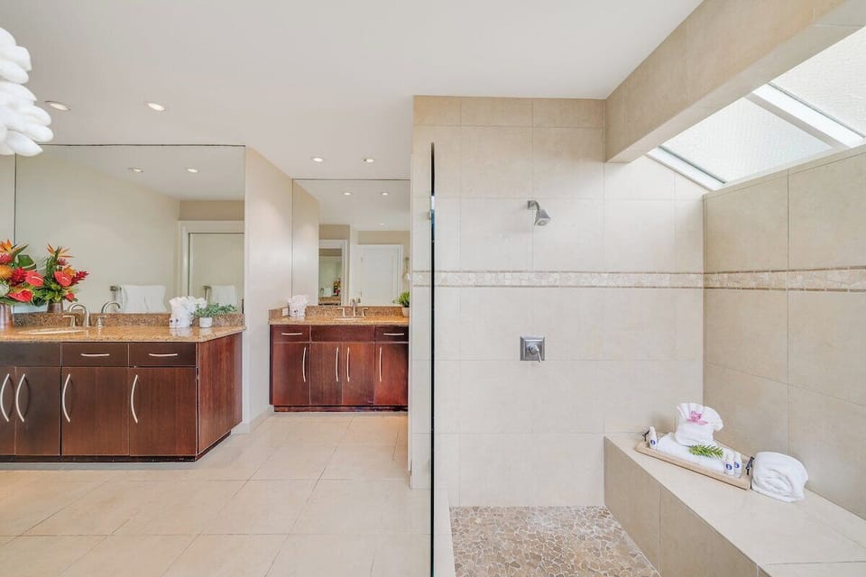 Clean and spacious bathroom with a walk-in shower, tiled walls, and ample counter space for added comfort and convenience.
