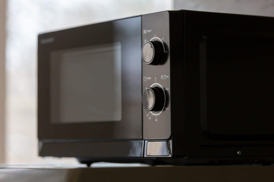 A modern microwave on a countertop, blending functionality with design.
