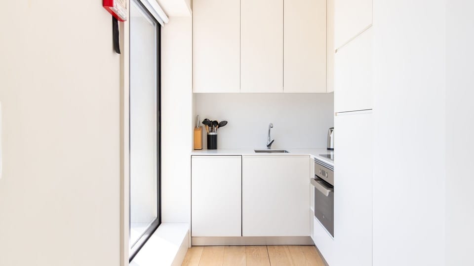 This compact, modern kitchenette offers everything you need to prepare light meals or morning coffee, bathed in natural light from the expansive window. Its sleek design makes cooking a breeze, ensuring a comfortable and convenient stay.