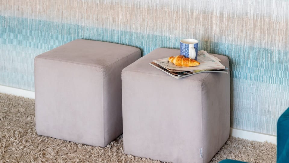 Unwind in a cozy corner of your living space where versatile ottomans provide flexible seating or a convenient surface for your morning coffee and a good book. It's the perfect nook for quiet moments of relaxation.