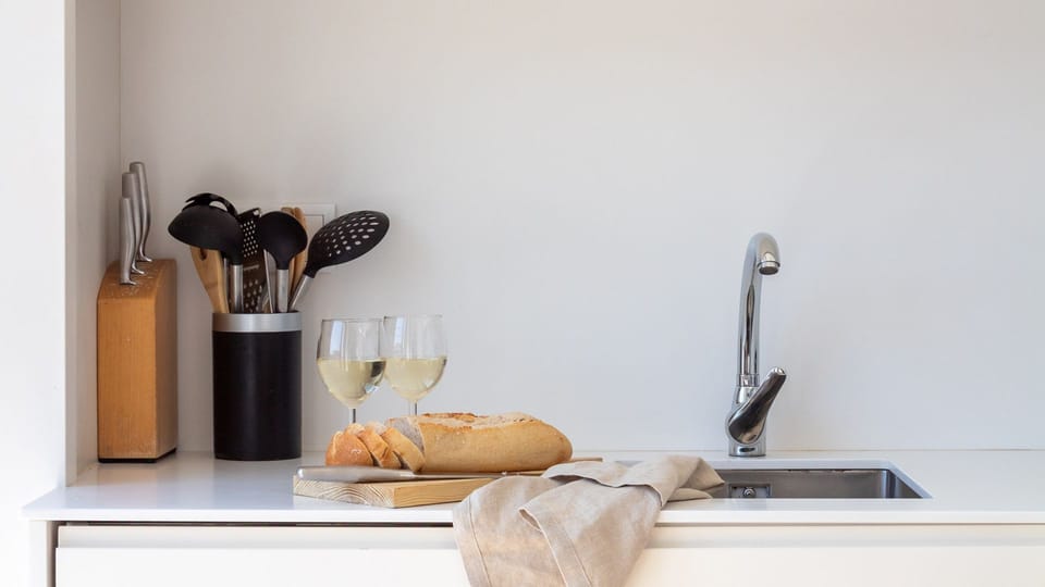 This sleek kitchen counter, equipped with essential utensils and a convenient sink, is ideal for preparing light snacks or enjoying a glass of local wine. It's perfect for casual moments and easy meal prep during your stay.