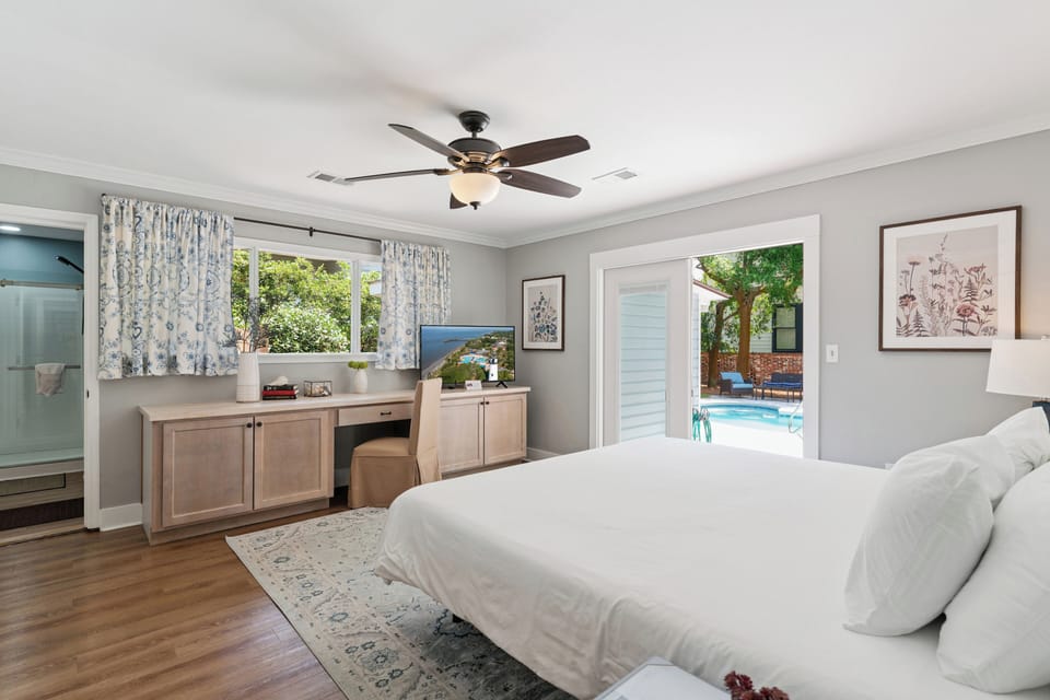 Sink into crisp white linens, enjoy views of your private pool, and feel the cool breeze from the ceiling fan as you unwind in your serene bedroom retreat.