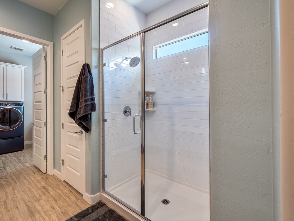 Master bathroom w/ custom tile shower, relaxation bench and access to laundry.