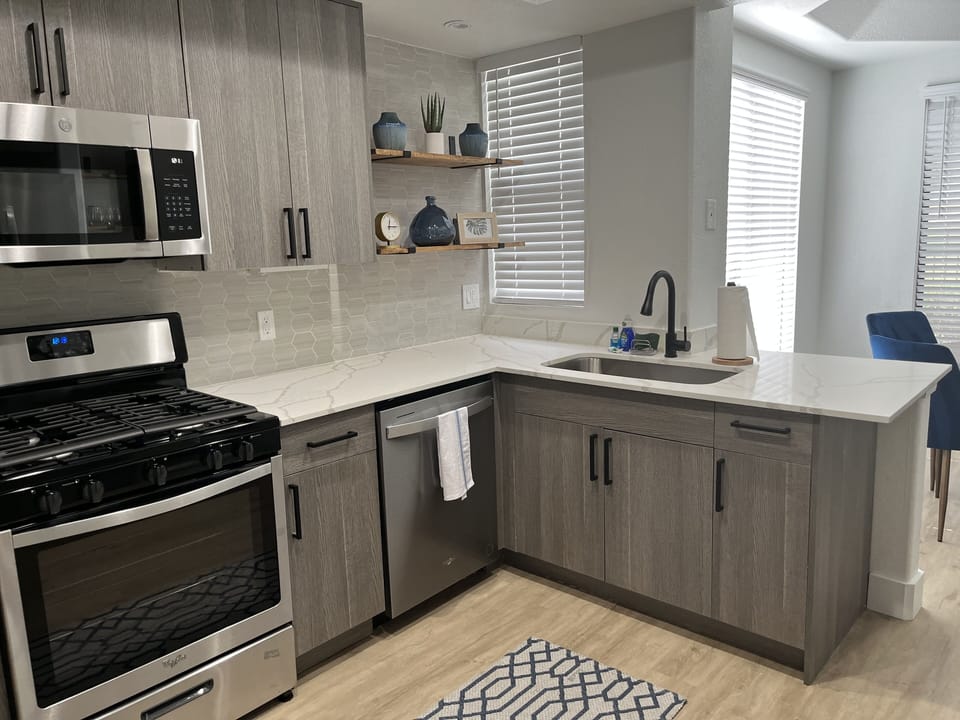 Kitchen w/ quartz counter, stainless appliances and fully stocked