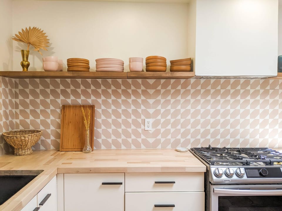 Fully stocked kitchen with West Elm plates, bowls, and glasses.