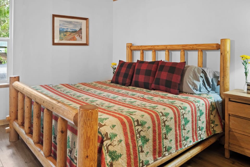 King size log bed with cozy bedding and cabin vibes