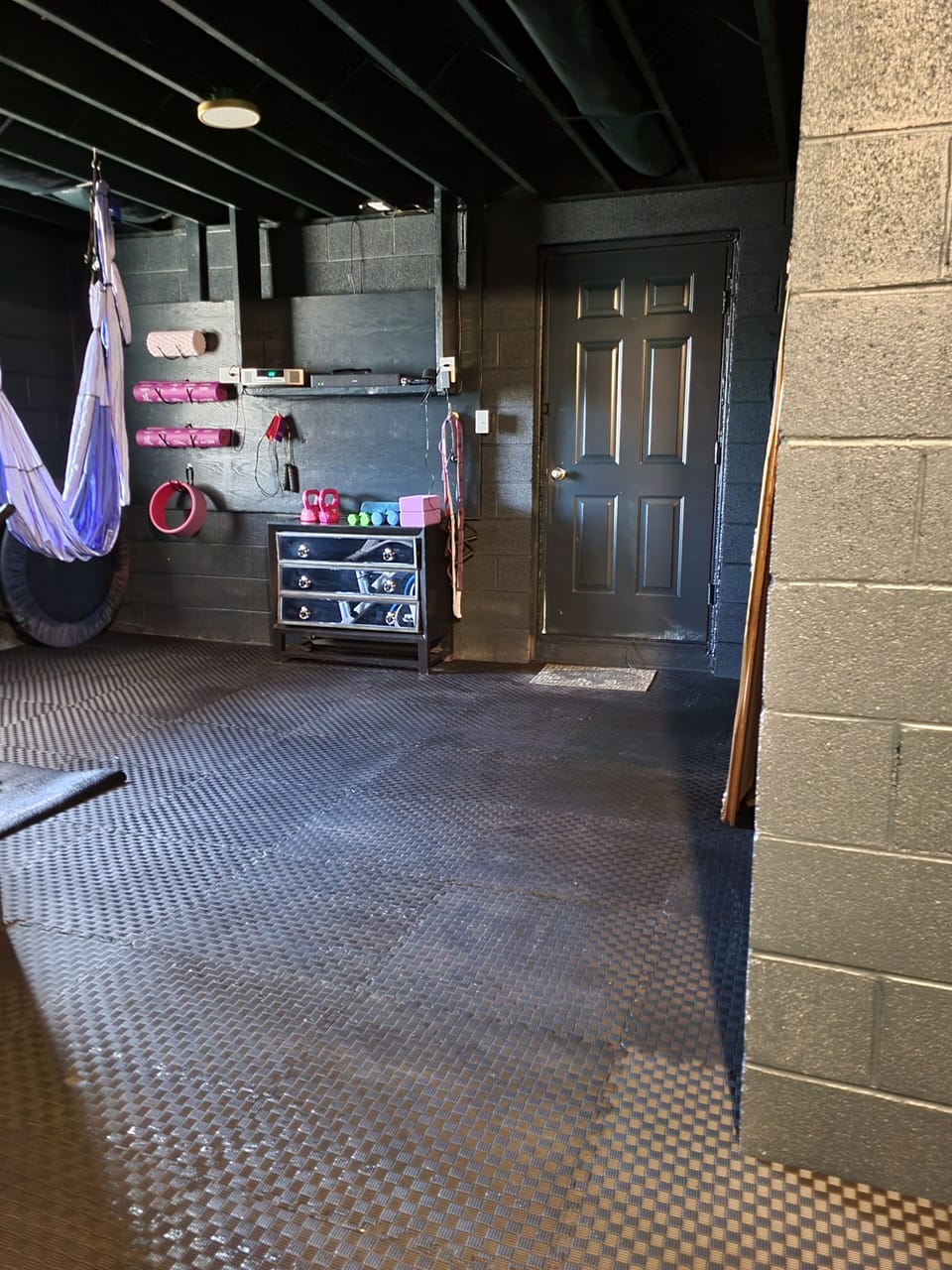 Yoga studio in basement with exercise bike.