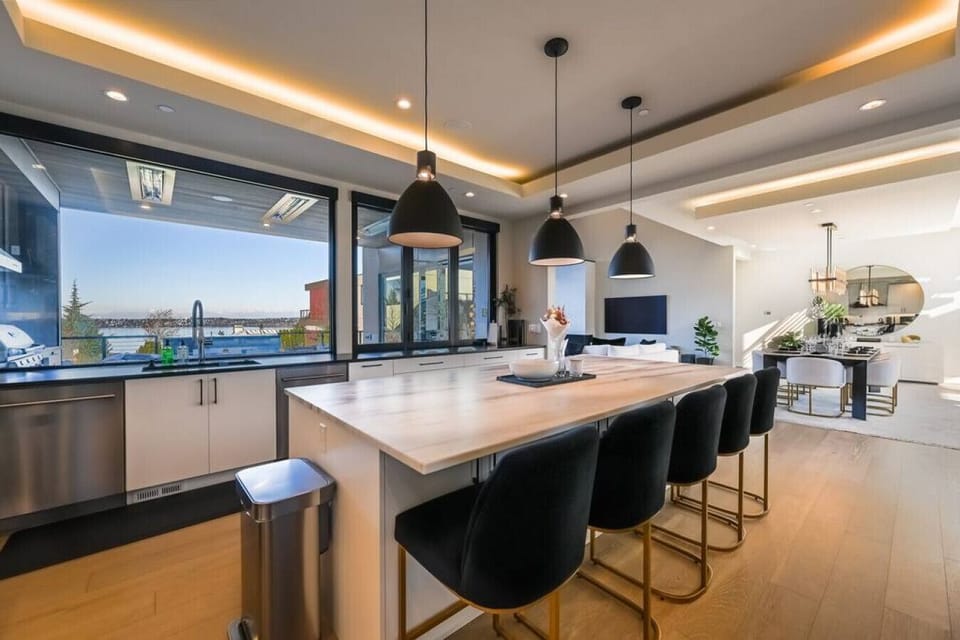 Views of Lake Washington from then kitchen. The main floor outdoor deck is immediately in front of the kitchen. Dining table and living room to the right.