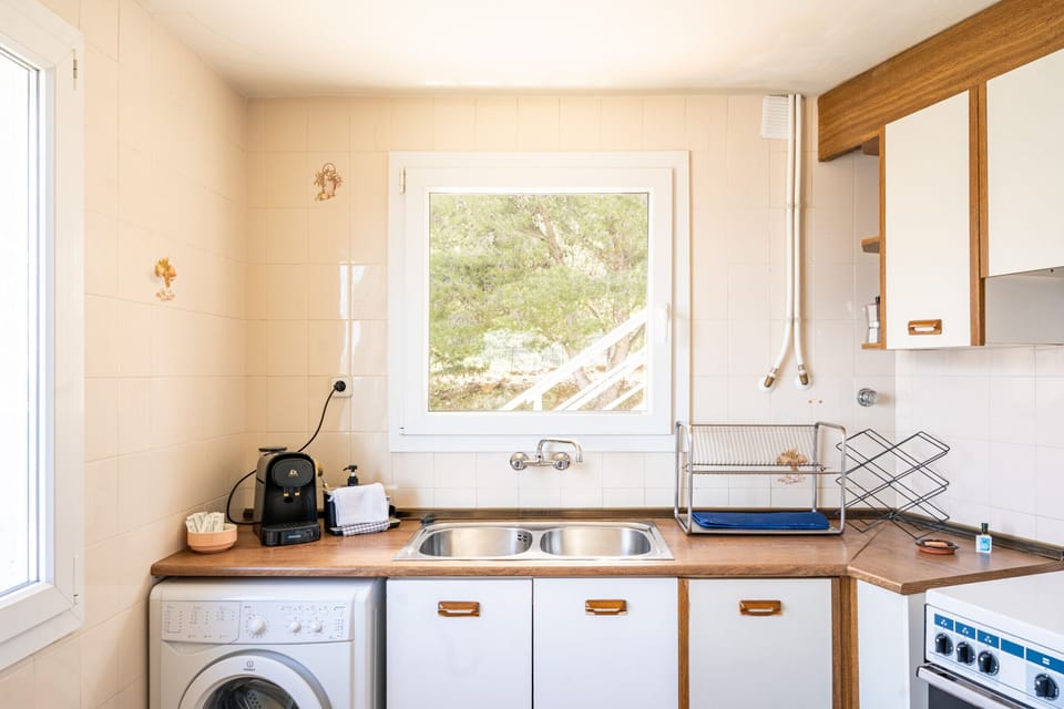 Kitchen on the first floor, with a double sink, washing machine and coffee maker — practical and well-equipped for a family holiday by the Costa Brava.