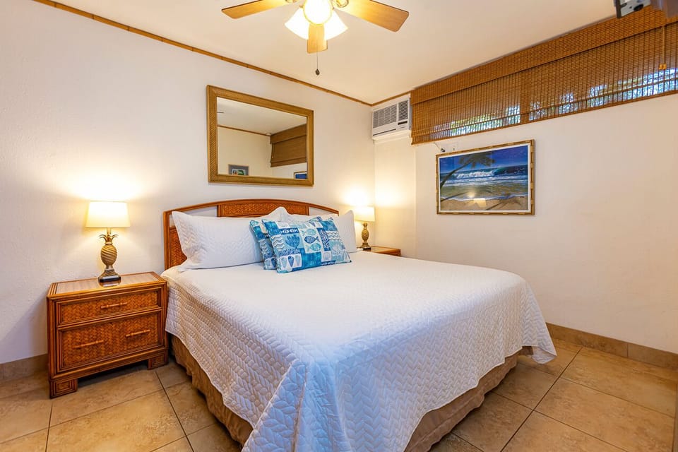 Step into your coastal retreat where crisp white linens and charming wicker details create the perfect backdrop for restful island nights.