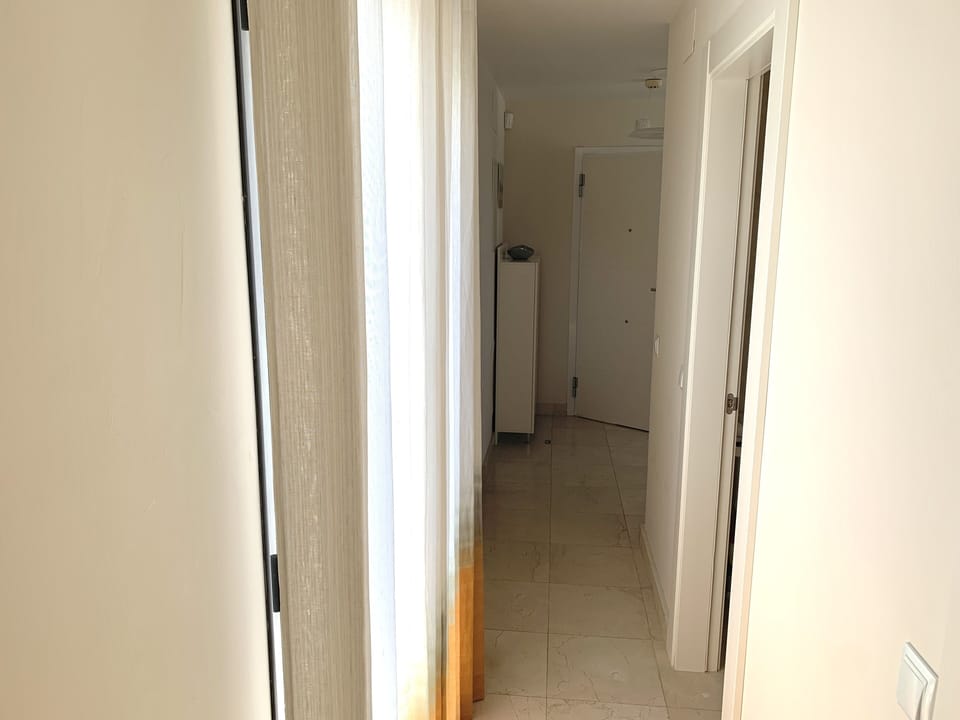 Corridor with east-facing terrace doors on the left and shower room to the right