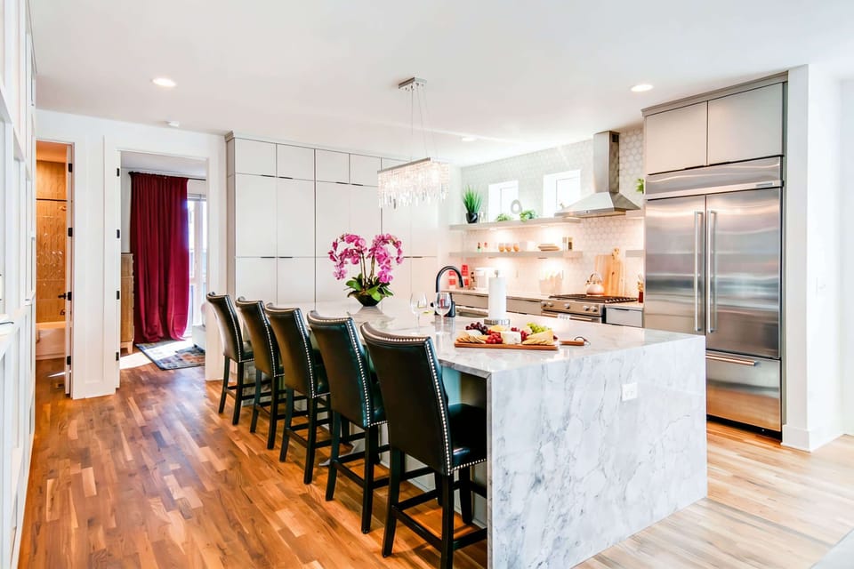 Marble countertop, bar seating, and pendant lights turn the kitchen island into the gathering spot where cooking and catching up naturally happen together