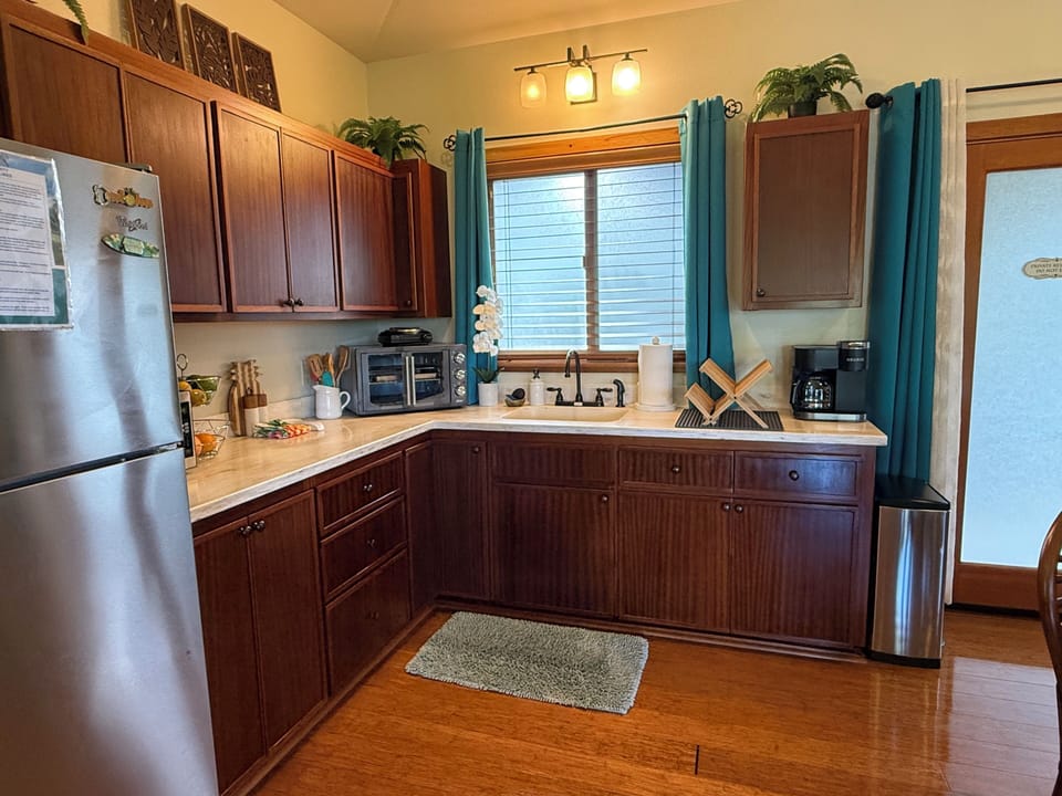 Kitchen-fridge, microwave, convection oven, burner, sink, and coffee maker.
