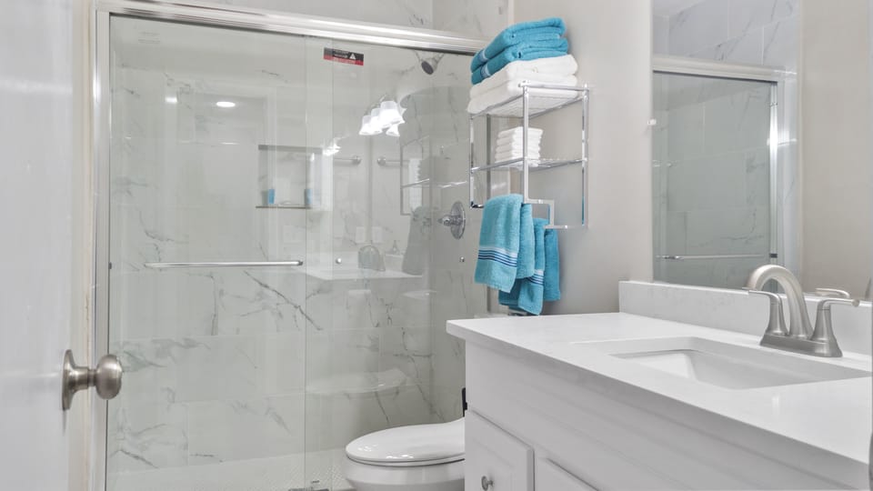 Renovated bathroom with stand up shower that features full ceramic tile surround