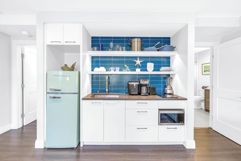 Kitchenette with coffee station and mini fridge.