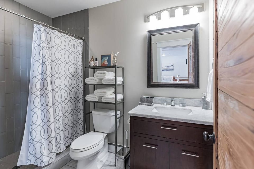 Bathroom has a spacious shower and basic necessities are provided.