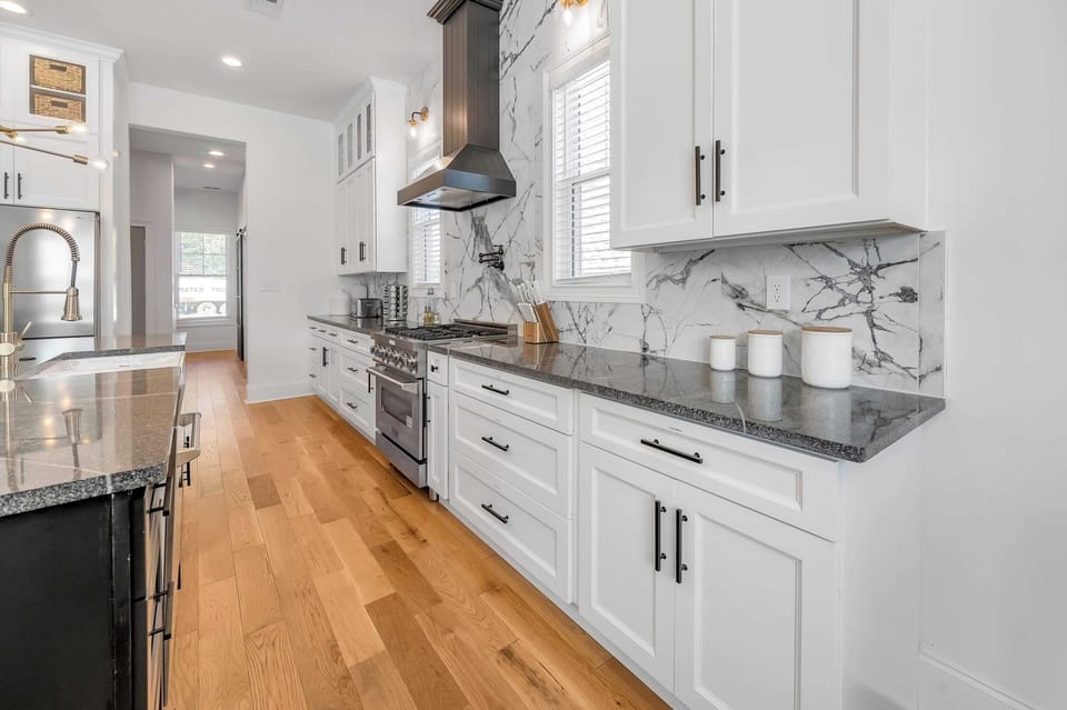 This glamorous modern inspired kitchen features gleaming cabinets, full appliances, and an elegant island countertop, thoughtfully designed to combine comfort and functionality.