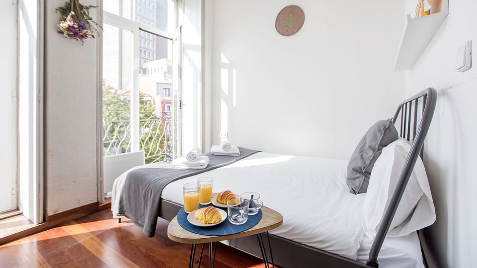A serene bedroom filled with natural light, creating a bright and relaxing space to unwind in Porto.

#PortoStay #AirbnbPorto #BrightBedroom #NaturalLight