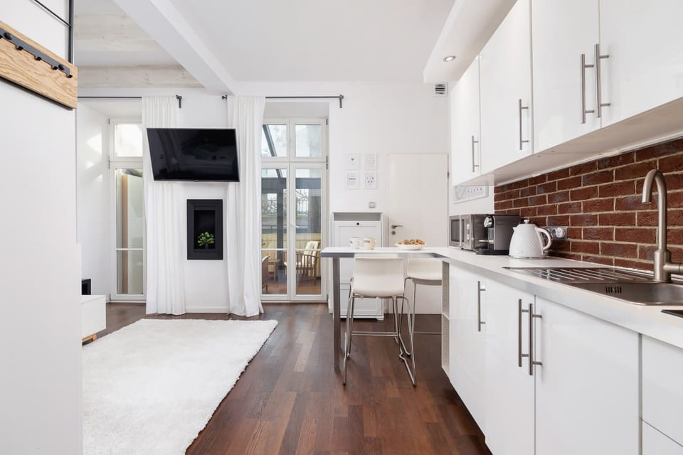 Bright and spacious kitchen featuring brick backsplash details.
