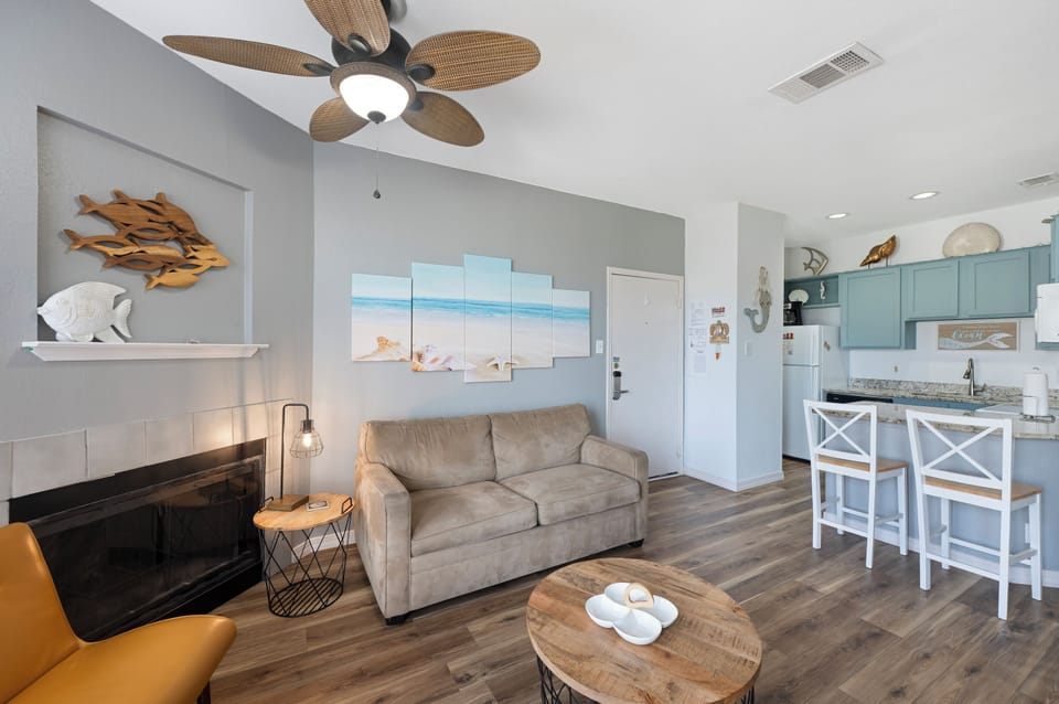 Kick back in your beachy living space, where calming coastal tones, plush seating, and a soft ceiling fan breeze set the tone for total relaxation.