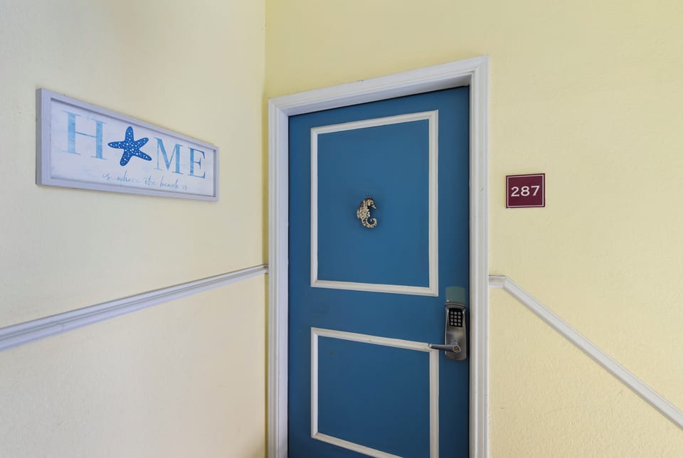 Step into your charming retreat through this welcoming blue door, where warm yellow walls and thoughtful details create your perfect getaway.