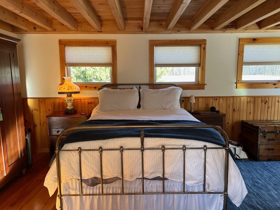 Settle in for a quiet night in this warmly furnished bedroom. Upper floor, large queen bed with an en suite bathroom. 4+ pillows. Down comforter.