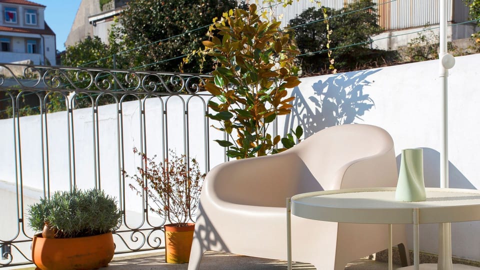 Discover your tranquil private terrace, an inviting outdoor haven complete with comfortable seating and lush potted plants. This serene escape provides a peaceful spot to enjoy the fresh air and sunshine.