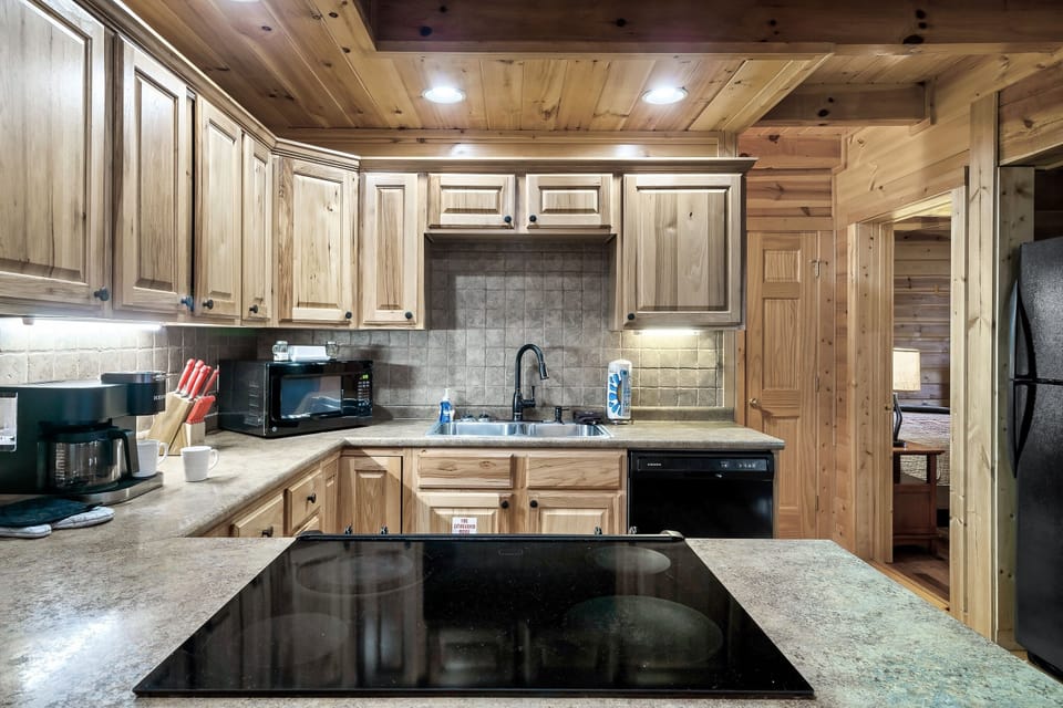 - Warm cabin kitchen with stone backsplash and full cooking setup   - Ideal space for prepping meals before exploring Smoky Mountain trails   - Bright inviting layout connecting perfectly with the living room area