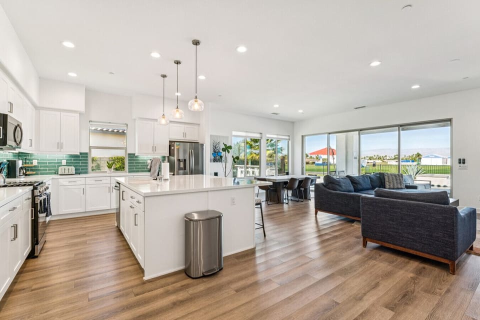Bright kitchen w/ large island, bar seating & wide views into the living area