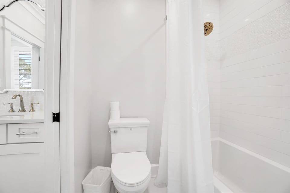Step into your pristine white bathroom where clean lines and bright tiles create a refreshing spa-like retreat for your daily routines.