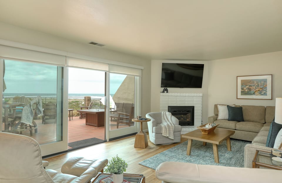 The living room is nestled at sea level, just down a flight of stairs. It features a cozy natural gas fireplace, a SmartTV for all your entertainment needs, and a sectional sofa with a queen pullout for extra guests.