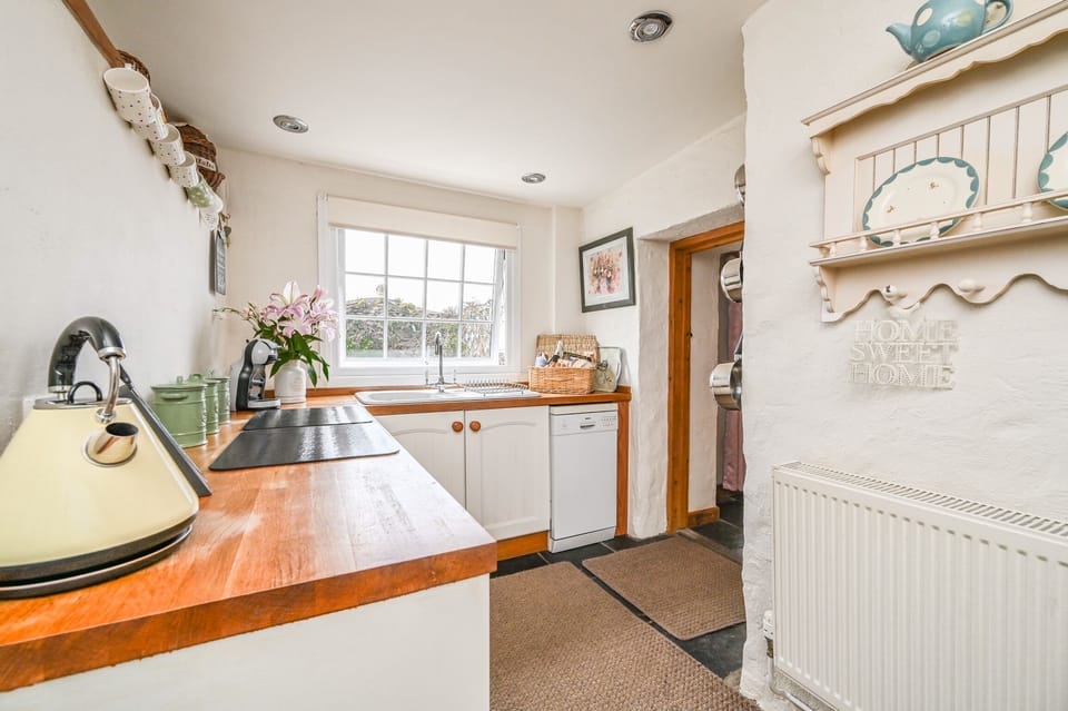 Kitchen with door leading to level dining area and steps to upper decking 
