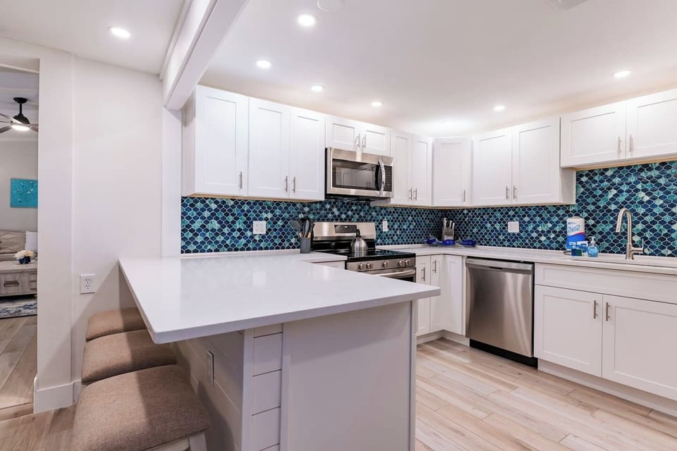 Stunning Kitchen: Enjoy stylish cooking with ocean-hued tiles and modern appliances!